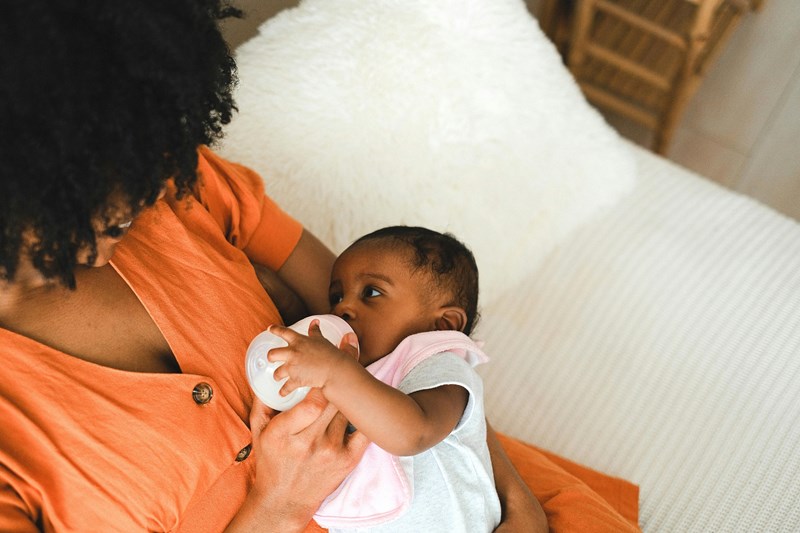 Baby being fed with bottle