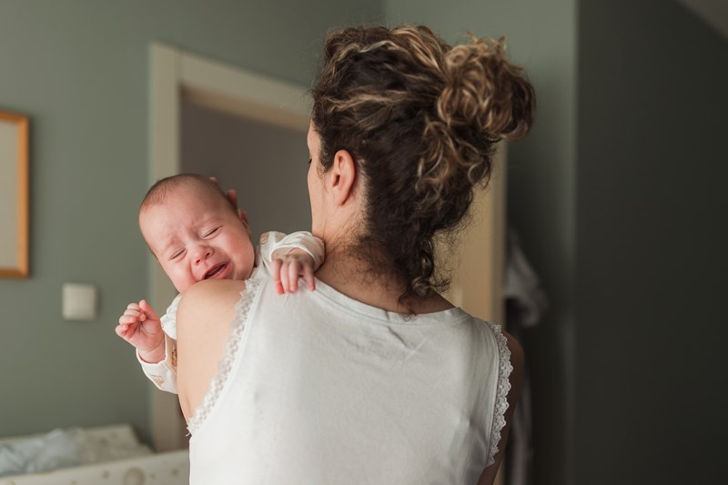 Woman taking car of a crying newborn baby